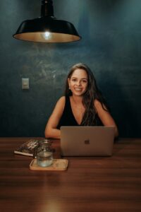 A woman sitting at a table with her laptop